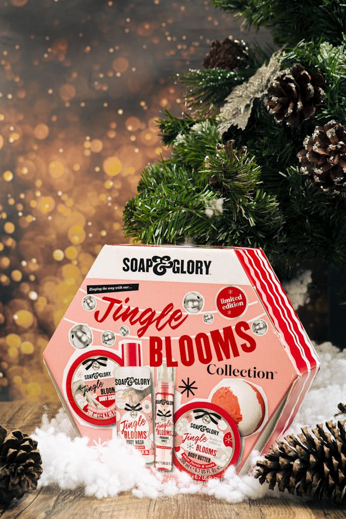 Holiday-themed Jingle Blooms gift set surrounded by festive pine branches and snow.